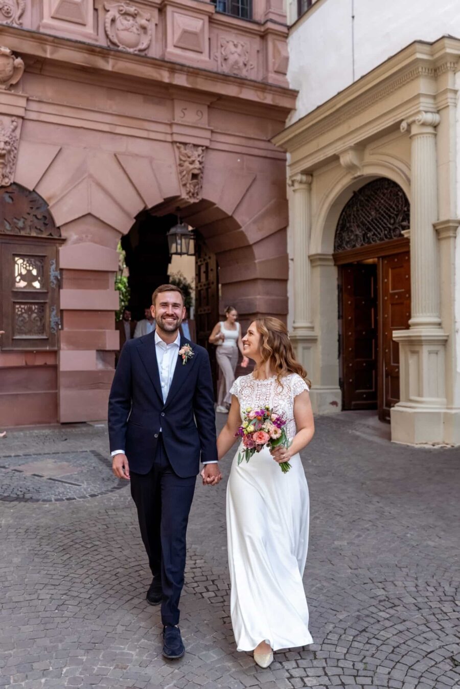 Hochzeit Steinburg Würzburg | Editorial Style & Party | Florian Knusper 95 Brautpaar beim Spaziergang vor historischem Gebäude