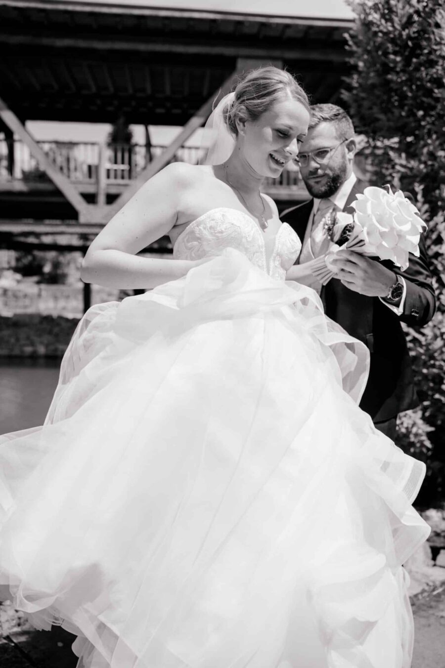 Brautpaar mit Blumenstrauß vor Holzkulisse