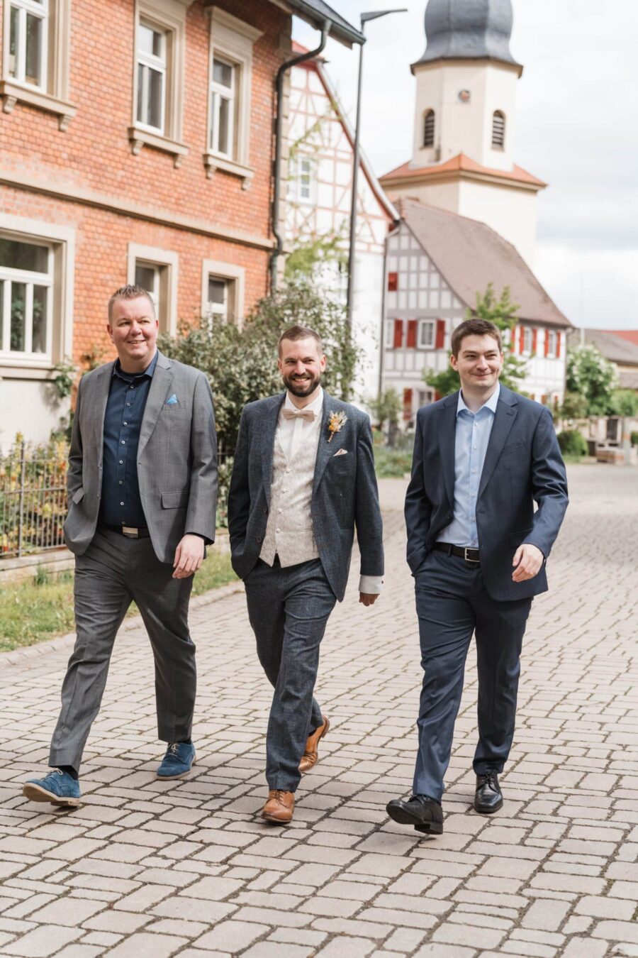 Bräutigam und Freunde spazieren im Dorf.