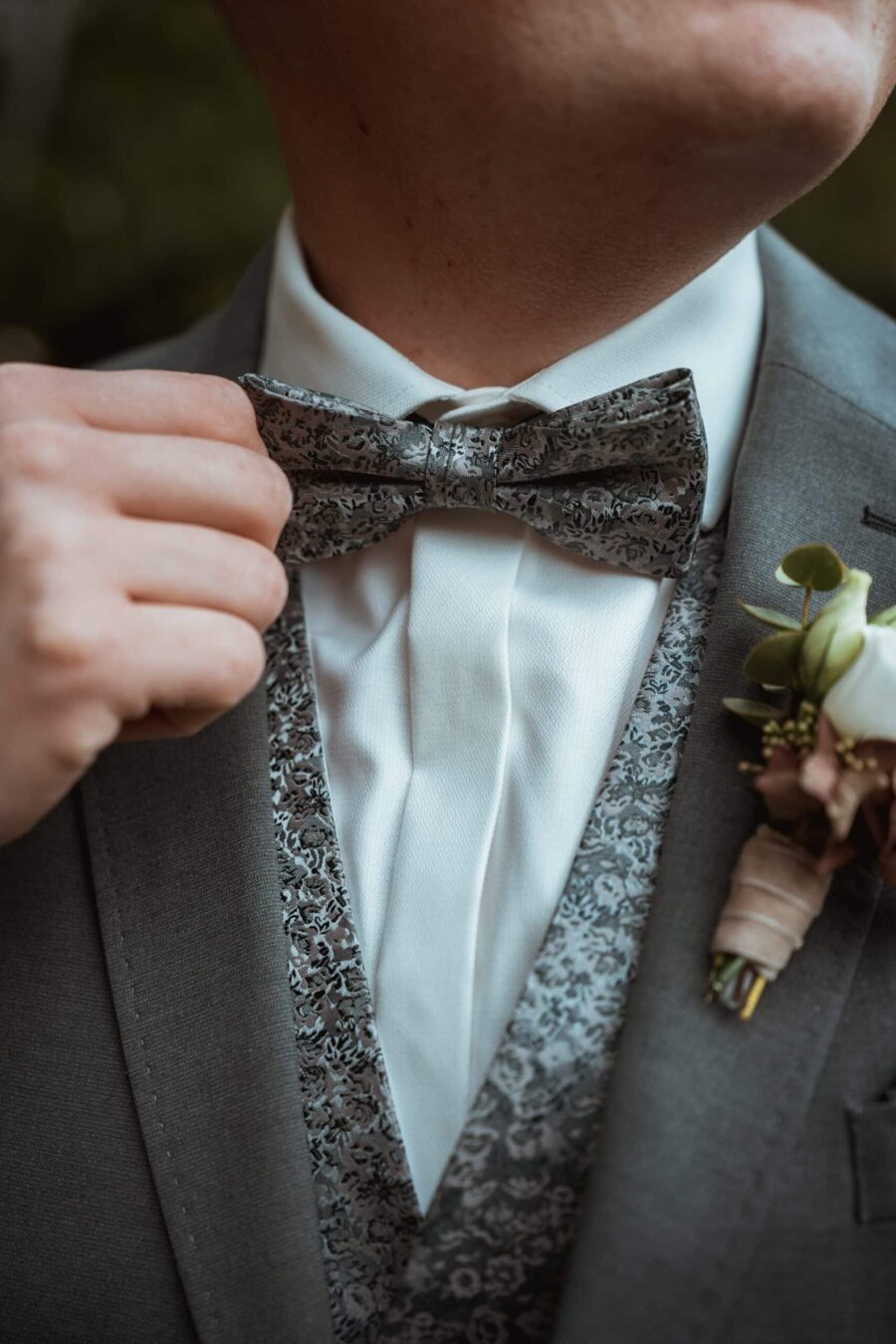 Anzug mit gemusterter Fliege und Ansteckblume