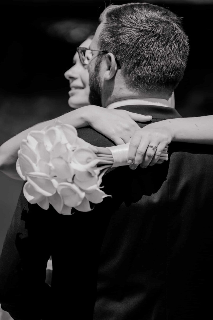 Brautpaar umarmt mit Blumenstrauß