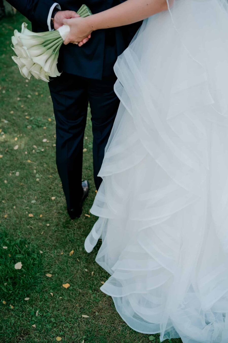 Brautpaar auf Wiese mit Blumenstrauß