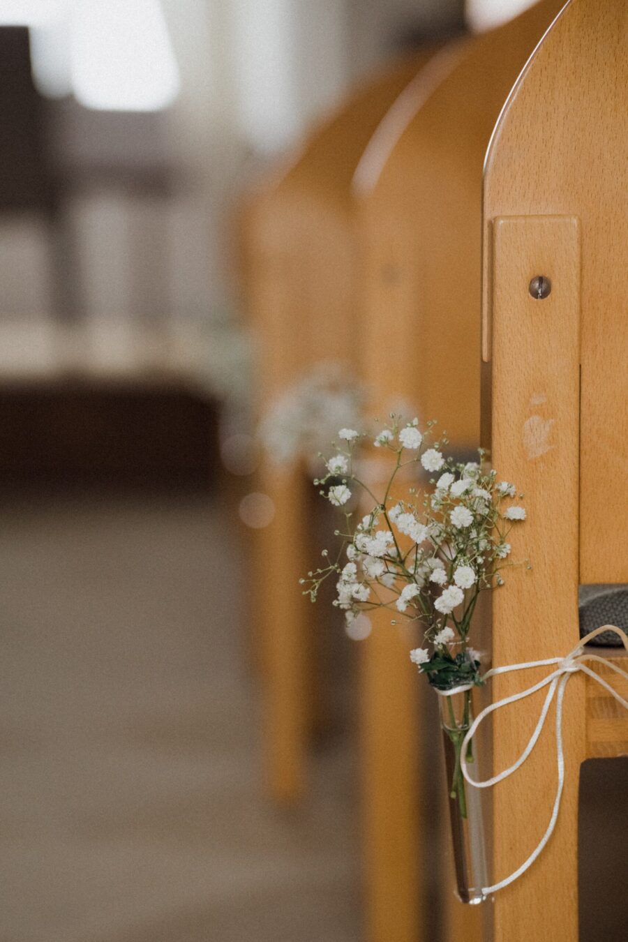 Holzbank mit Blumendeko für Hochzeit dekoriert