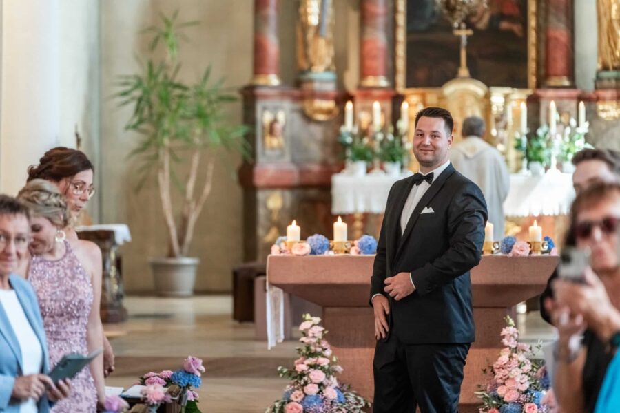 Kirchliche Trauung mit Blumendekoration und Gästen