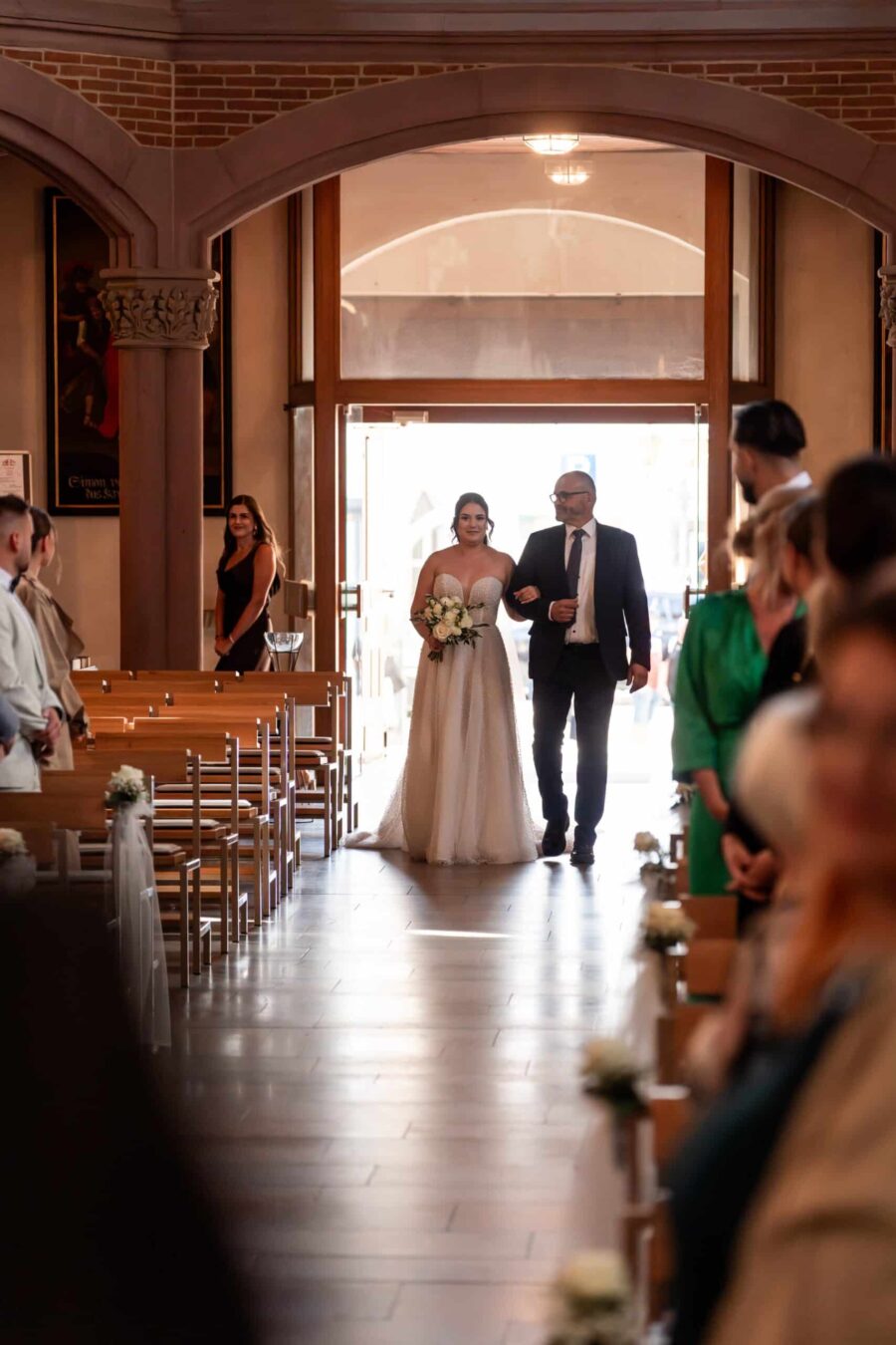 Brautpaar schreitet den Kirchgang entlang