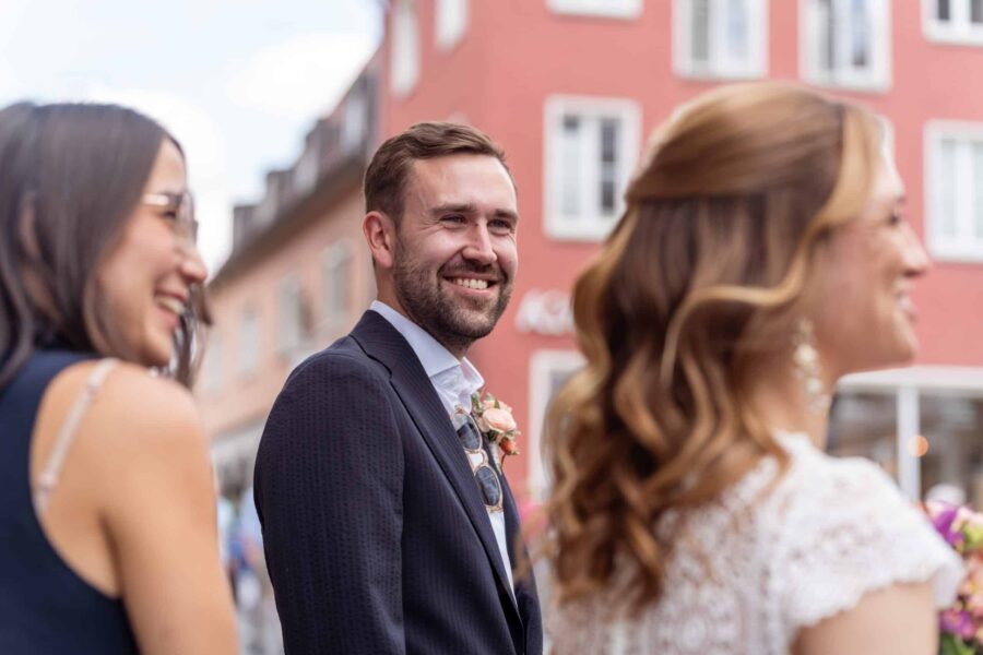 Hochzeit Steinburg Würzburg | Editorial Style & Party | Florian Knusper 3 Lächelnde Hochzeitsgäste in der Altstadt.