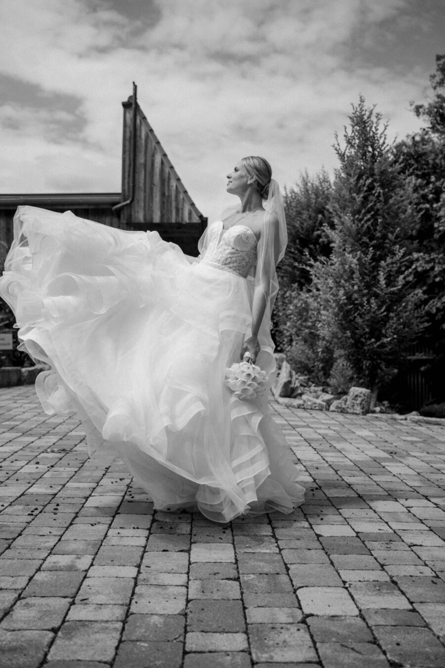 Braut im Kleid auf gepflastertem Platz im Freien