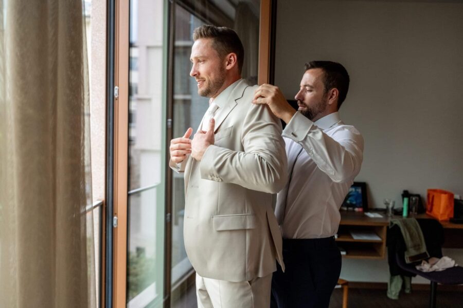 Bräutigam wird von Freund angekleidet