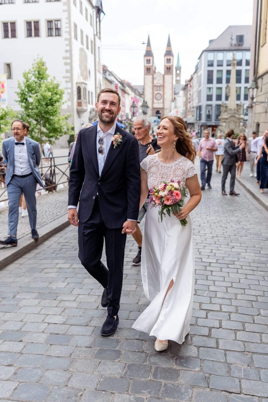 Brautpaar spaziert durch historische Altstadt.