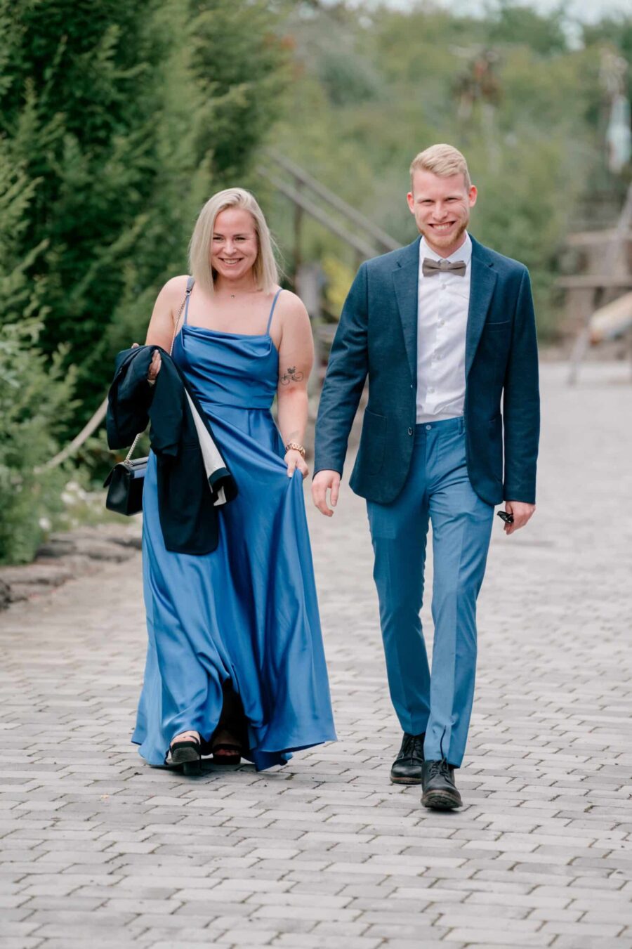 Gästepaar spaziert Hand in Hand im Gartenweg