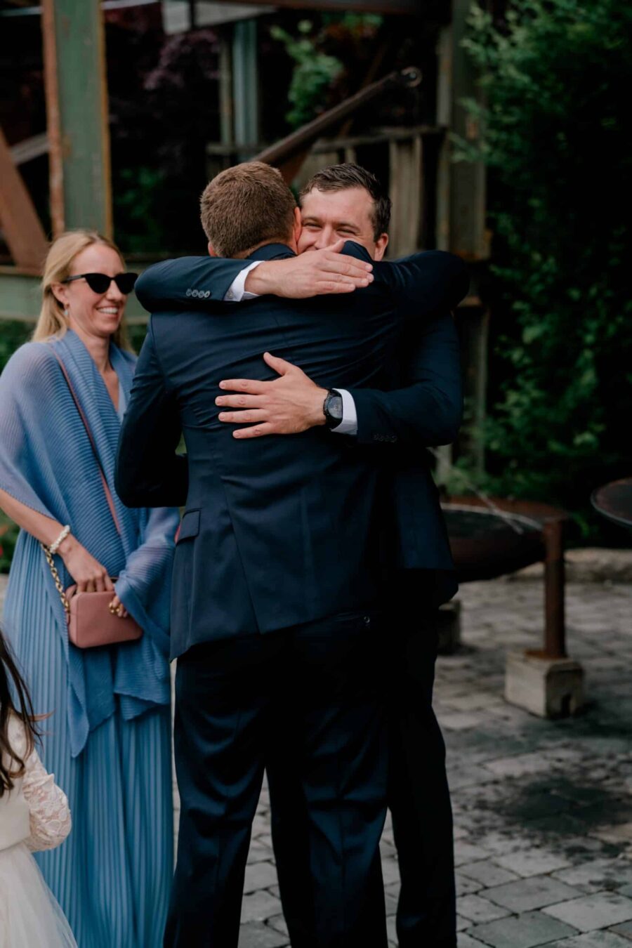 Gäste umarmen sich auf der Hochzeit im Freien