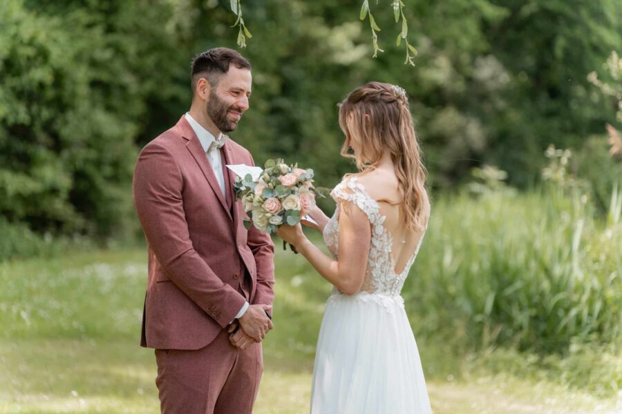 Brautpaar im Garten bei Trauung mit Blumenstrauß