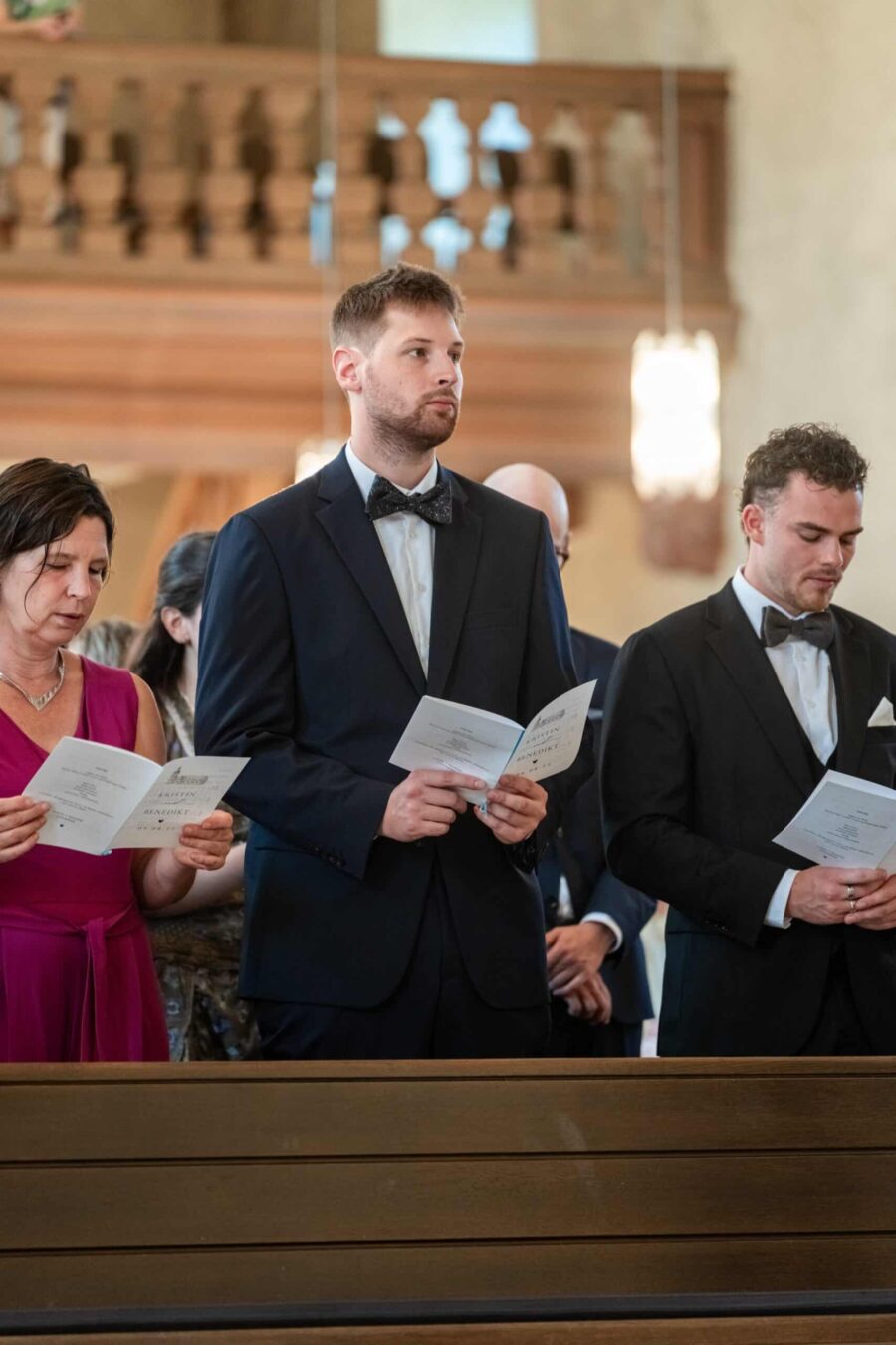 Gäste singen in der Kirche während Trauung