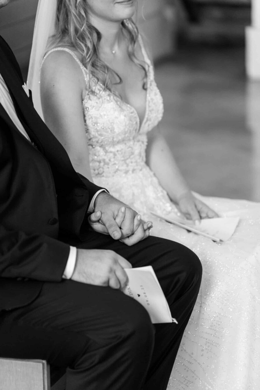 Brautpaar hält Händchen bei der Trauungszeremonie.