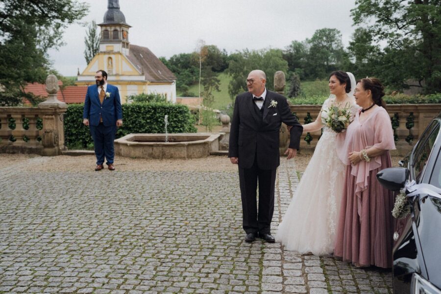 Brautpaar und Eltern im Schlossgarten vor der Trauung