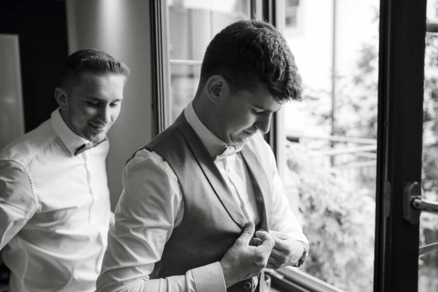 Bräutigam richtet Anzug vor Hochzeitsfeier.