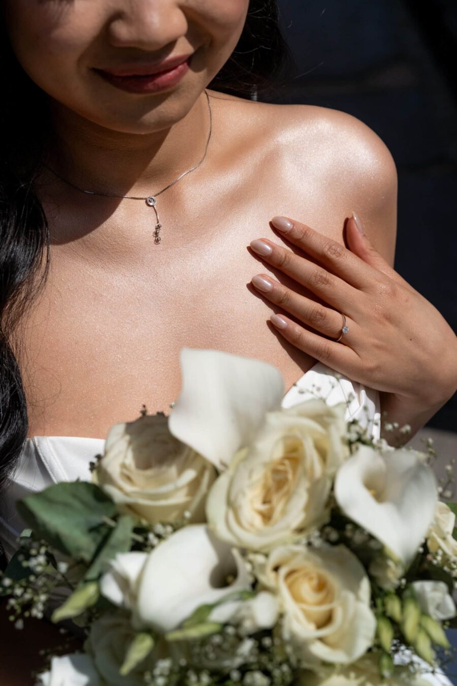 Braut hält Blumenstrauß mit weißem Blumendekor