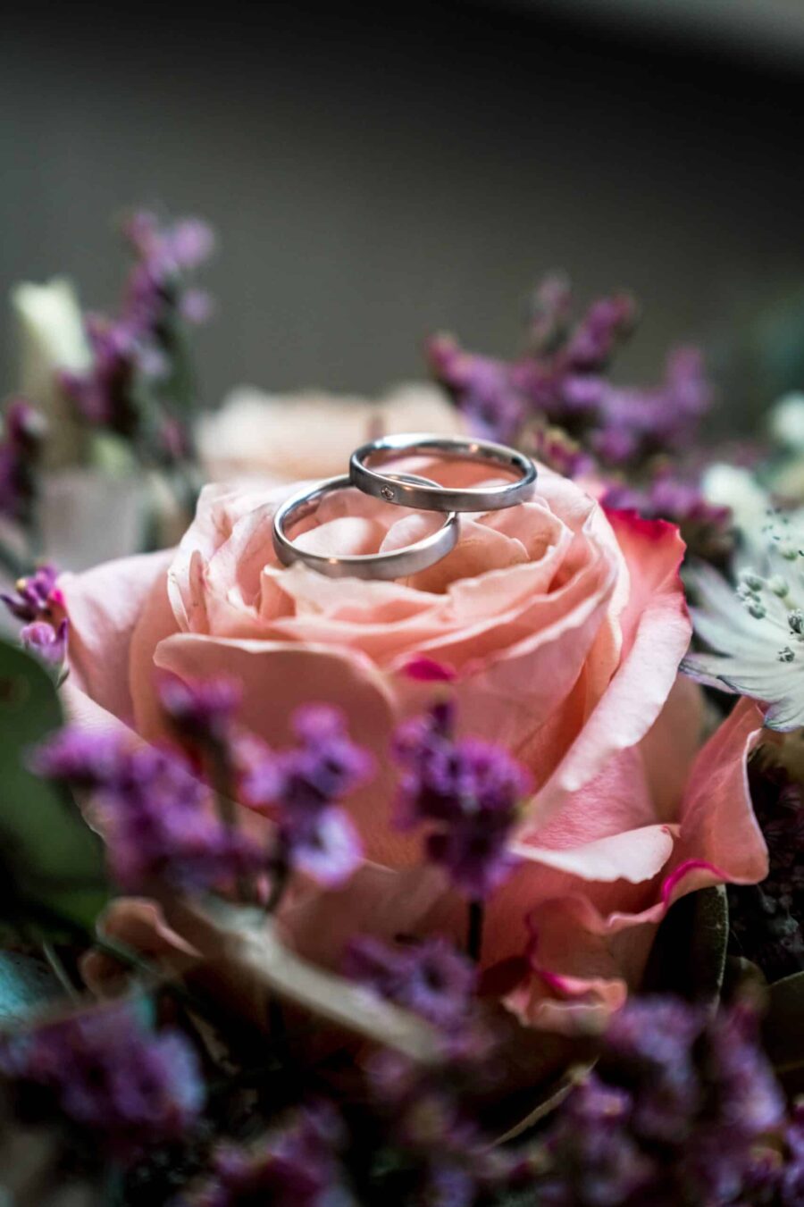 Eheringe auf rosafarbener Blume im Blumenarrangement