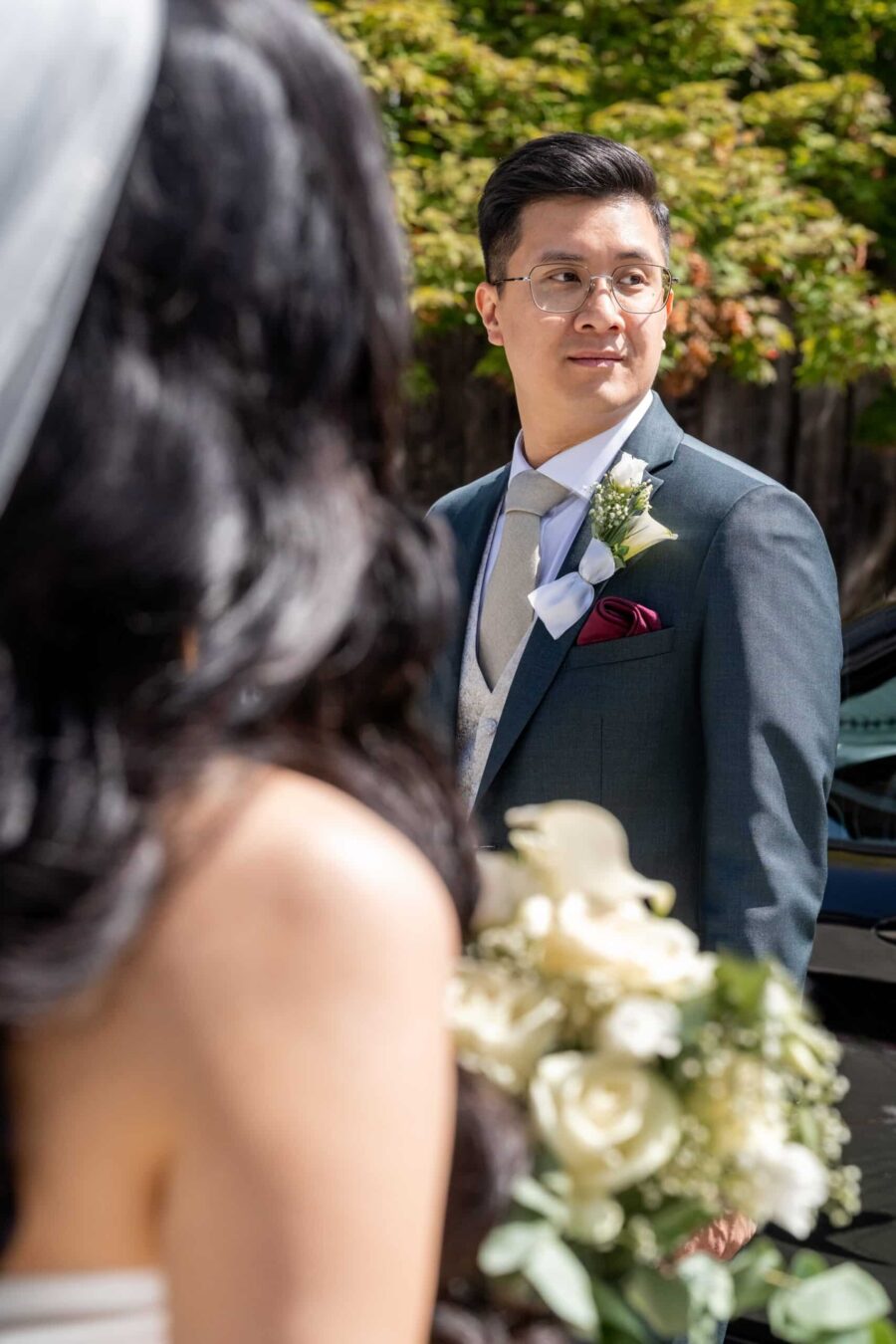 Bräutigam schaut Braut im Sommergarten an.