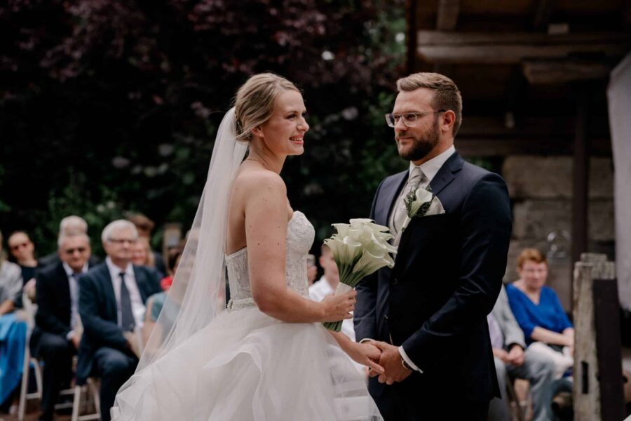 Brautpaar beim Ringtausch vor Hochzeitsgästen