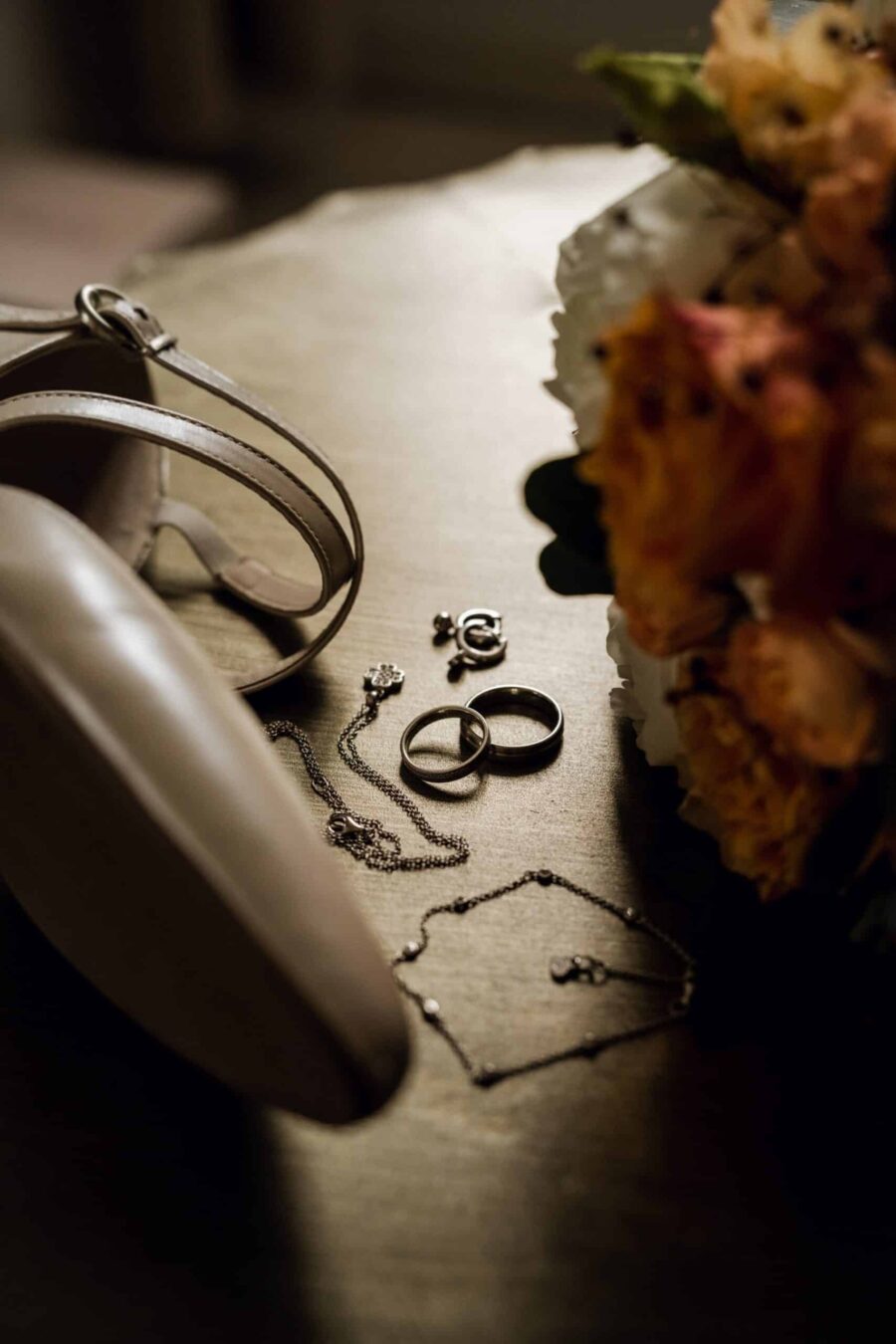 Brautaccessoires und Eheringe auf Holztisch