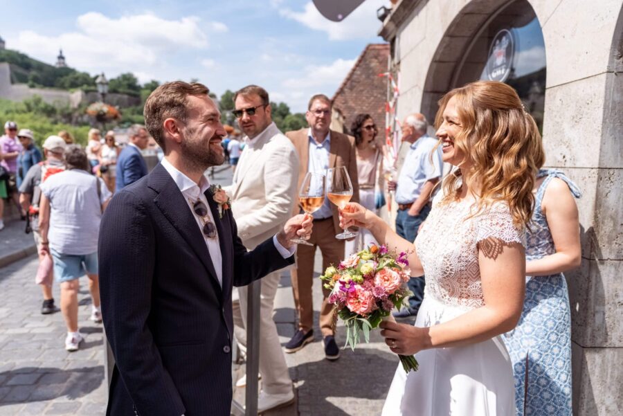 Hochzeitstoast mit Gästen im Freien