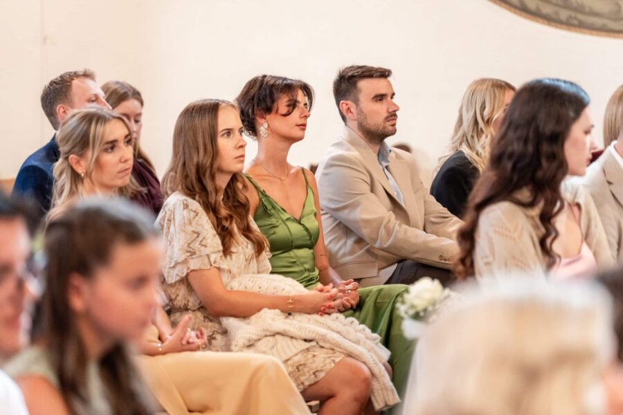 Hochzeitsgäste sitzen in der Zeremonie.