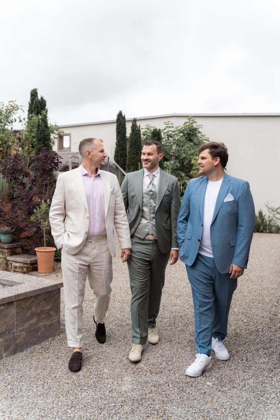 Gäste in eleganten Anzügen im Garten.