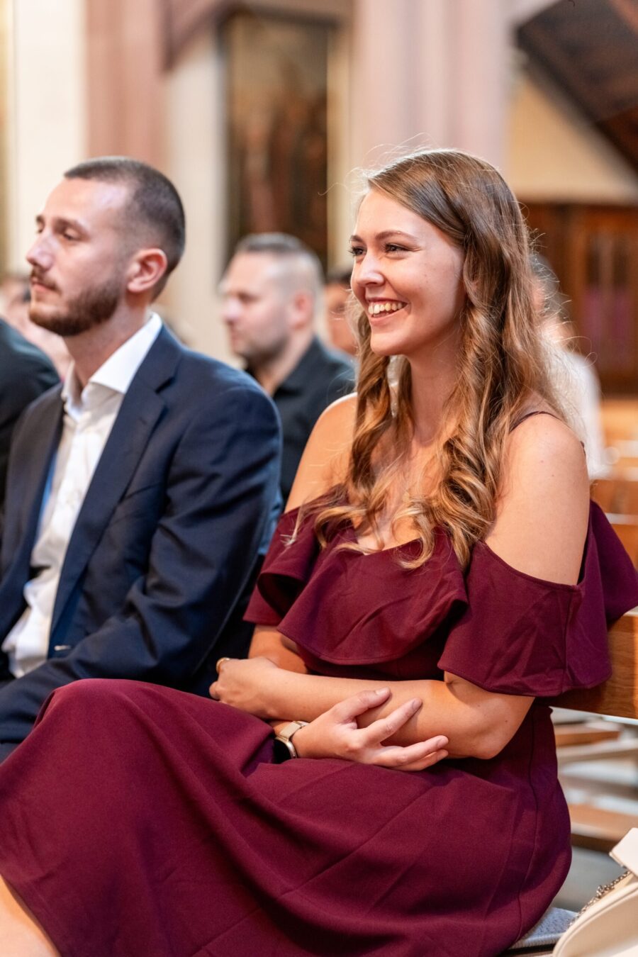 Gäste lächeln während der Trauungszeremonie in Kirche