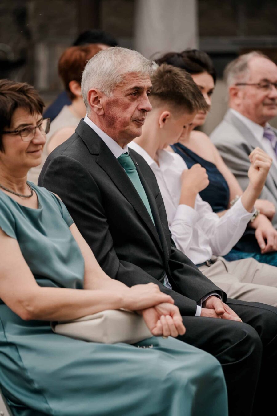 Gäste auf Hochzeitsfeier in eleganter Kleidung.