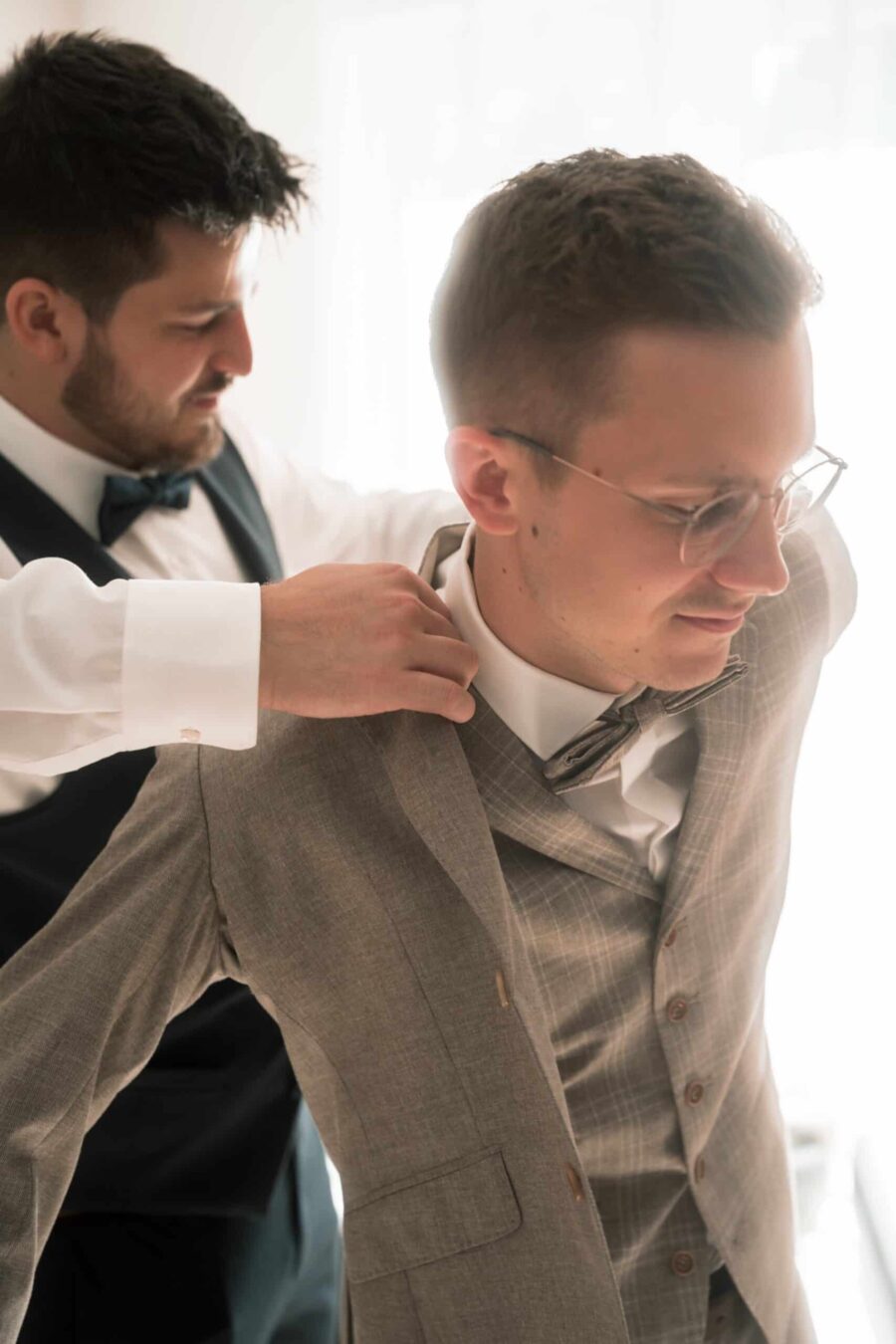 Bräutigam wird beim Ankleiden unterstützt