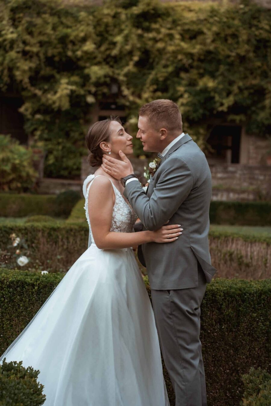 Brautpaar im Garten mit elegantem Brautkleid
