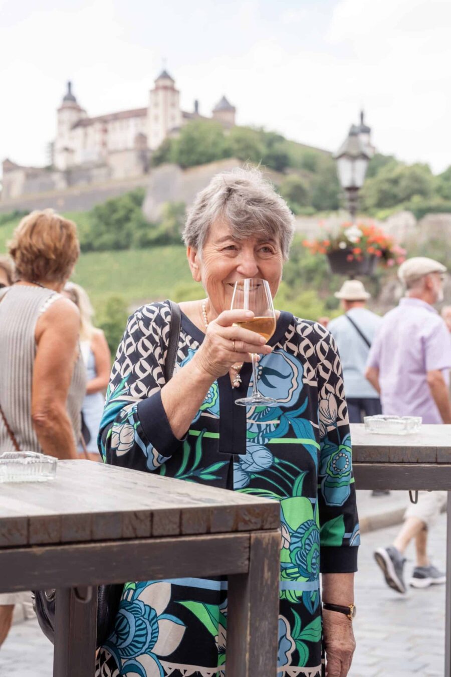 Hochzeit Steinburg Würzburg | Editorial Style & Party | Florian Knusper 10 Ältere Dame genießt Getränk bei Hochzeitsfeier draußen