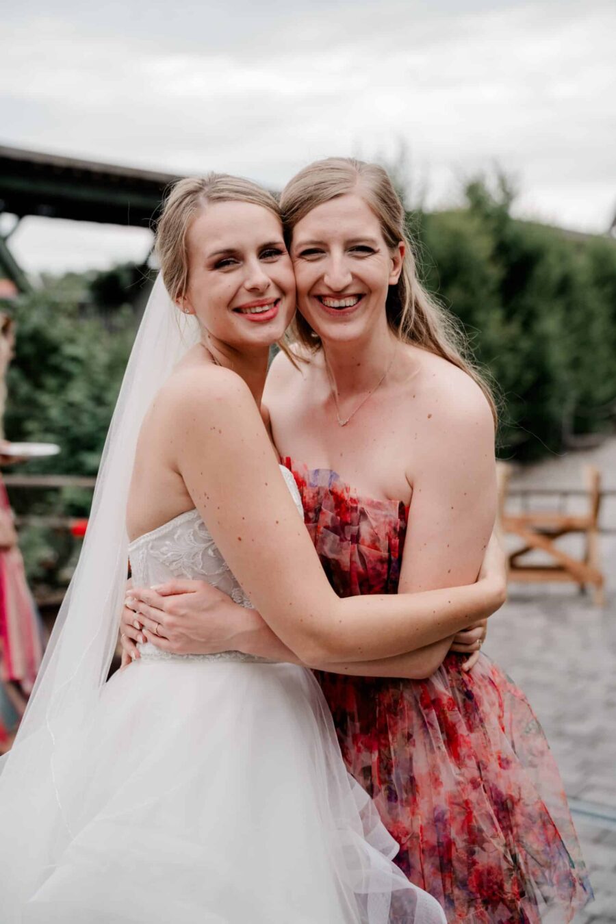 Braut tanzt mit Freundin im Garten nach der Trauung