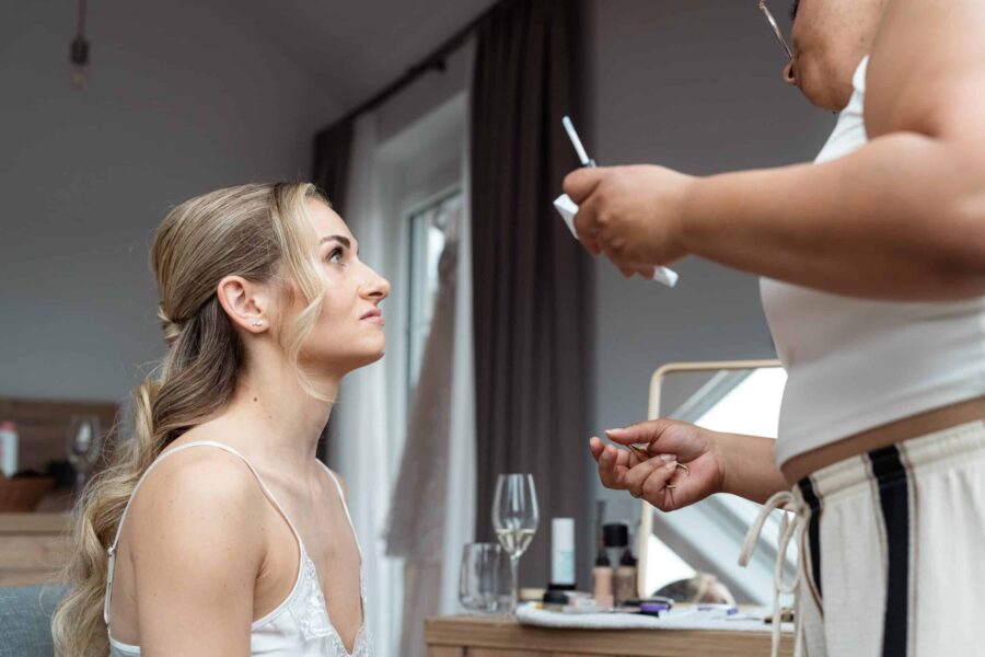 Braut beim Make-up-Styling vor der Hochzeit.
