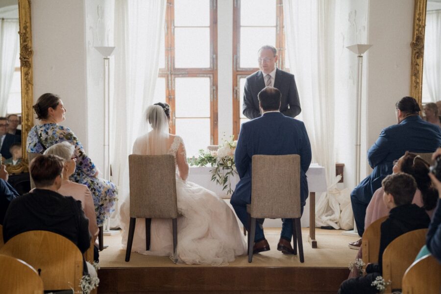 Zeremonie in lichtdurchflutetem Raum mit Gästen.