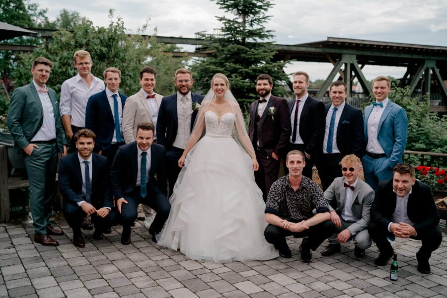 Brautpaar mit Hochzeitsgesellschaft im Garten.