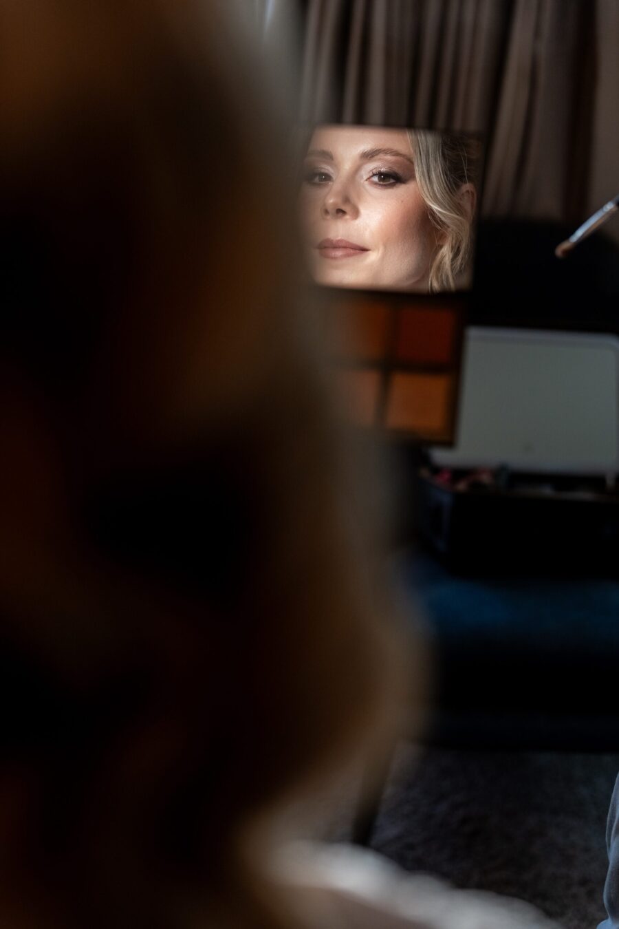 Braut macht Make-up mit Spiegel im Hintergrund