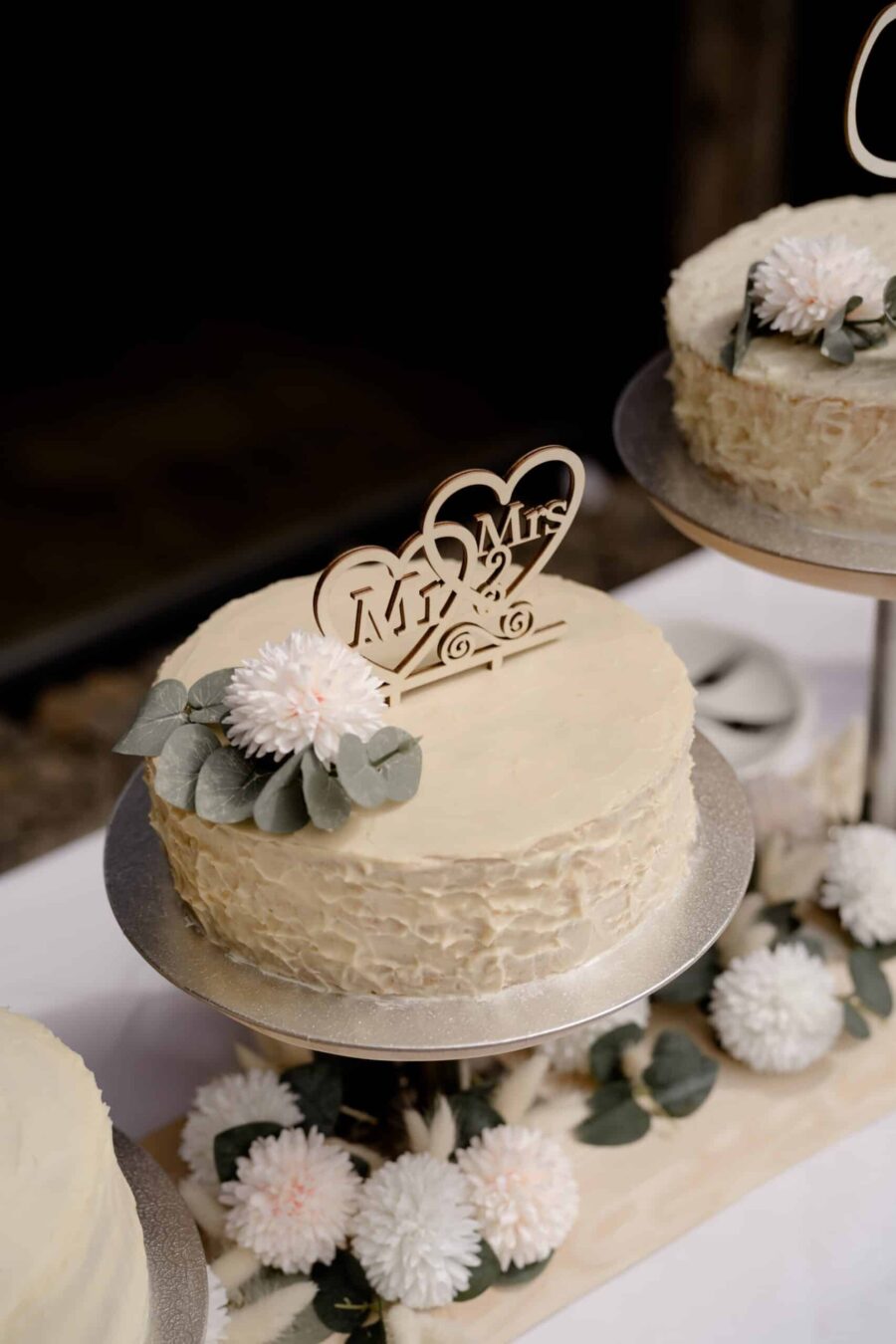 Hochzeitstorte mit Blumendeko und Herz-Topper