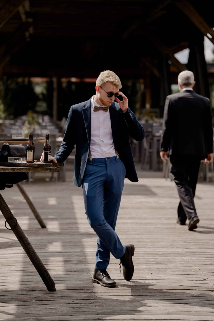 Eleganter Hochzeitsgast auf Holzboden mit Getränken.
