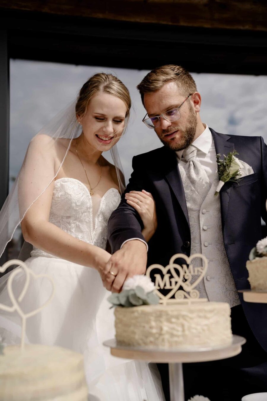 Brautpaar schneidet Hochzeitstorte zusammen