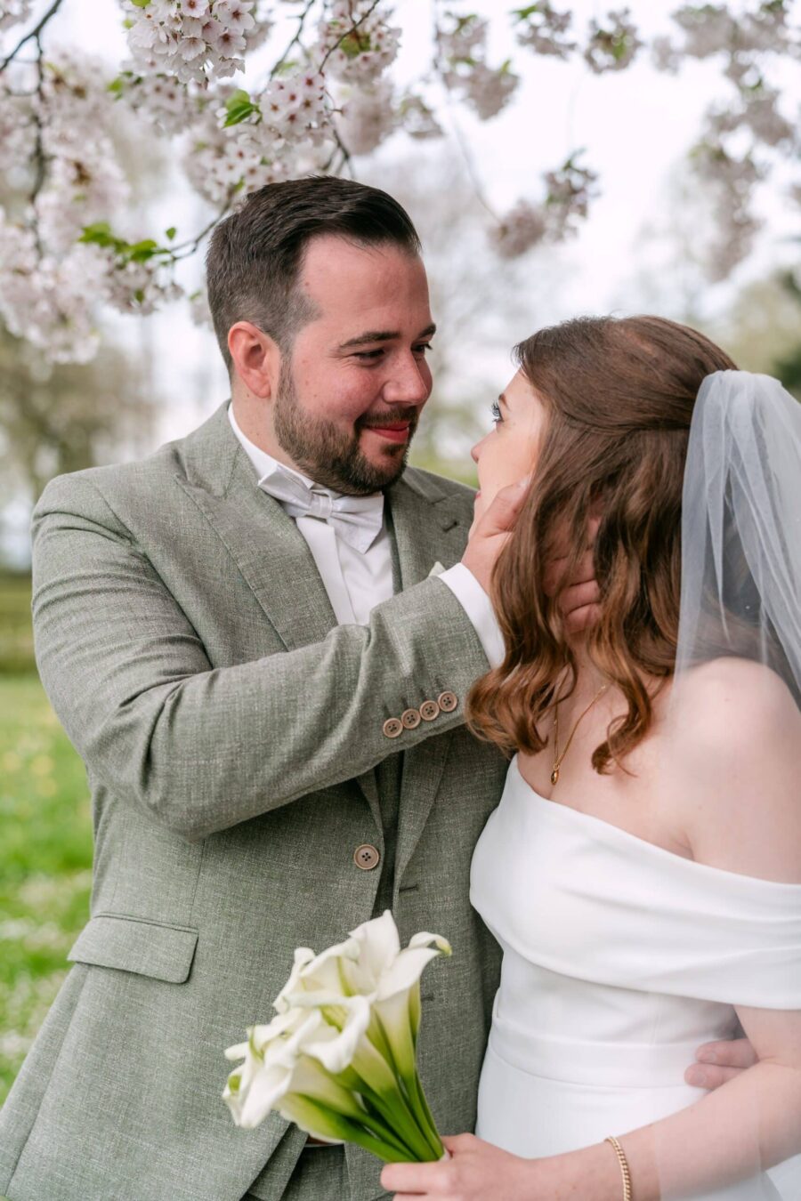 Hochzeit Insel Mainau Bodensee – Heiraten am Bodensee 138 Brautpaar unter Blütenzweigen, Braut mit Calla-Strauß