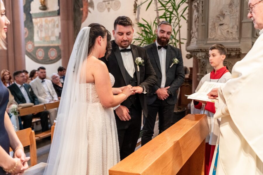 Brautpaar tauscht Ringe während der Trauung in Kirche