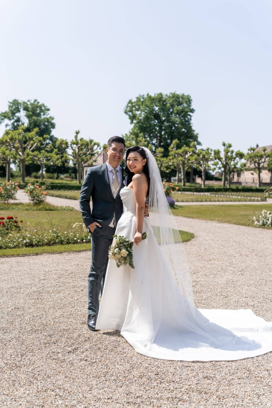 Brautpaar im Garten mit Blumenstrauß