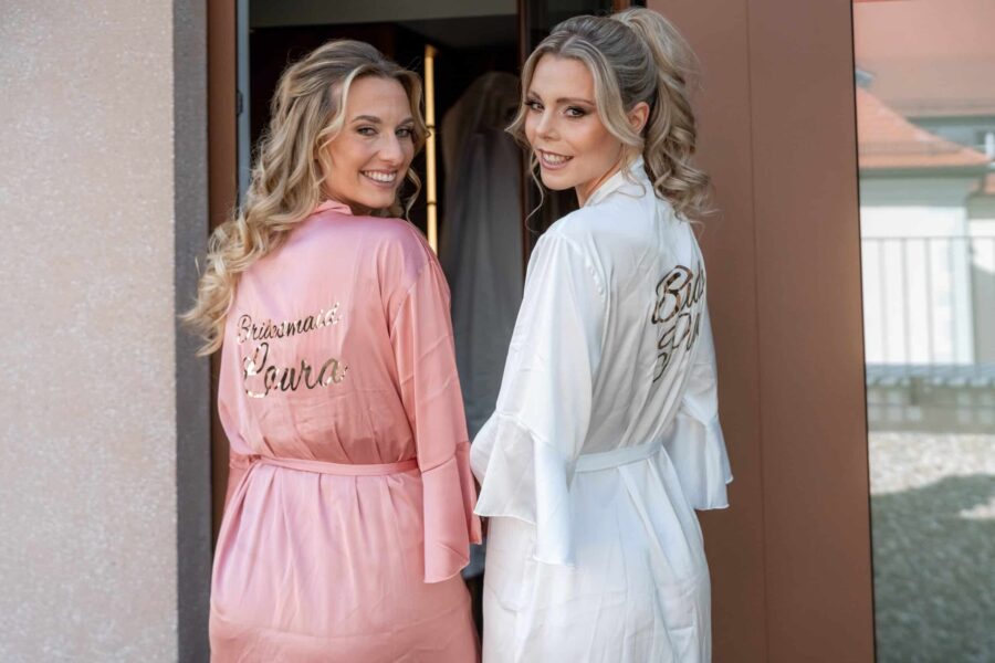 Brautjungfern in Morgenmänteln vor Hochzeitssuite