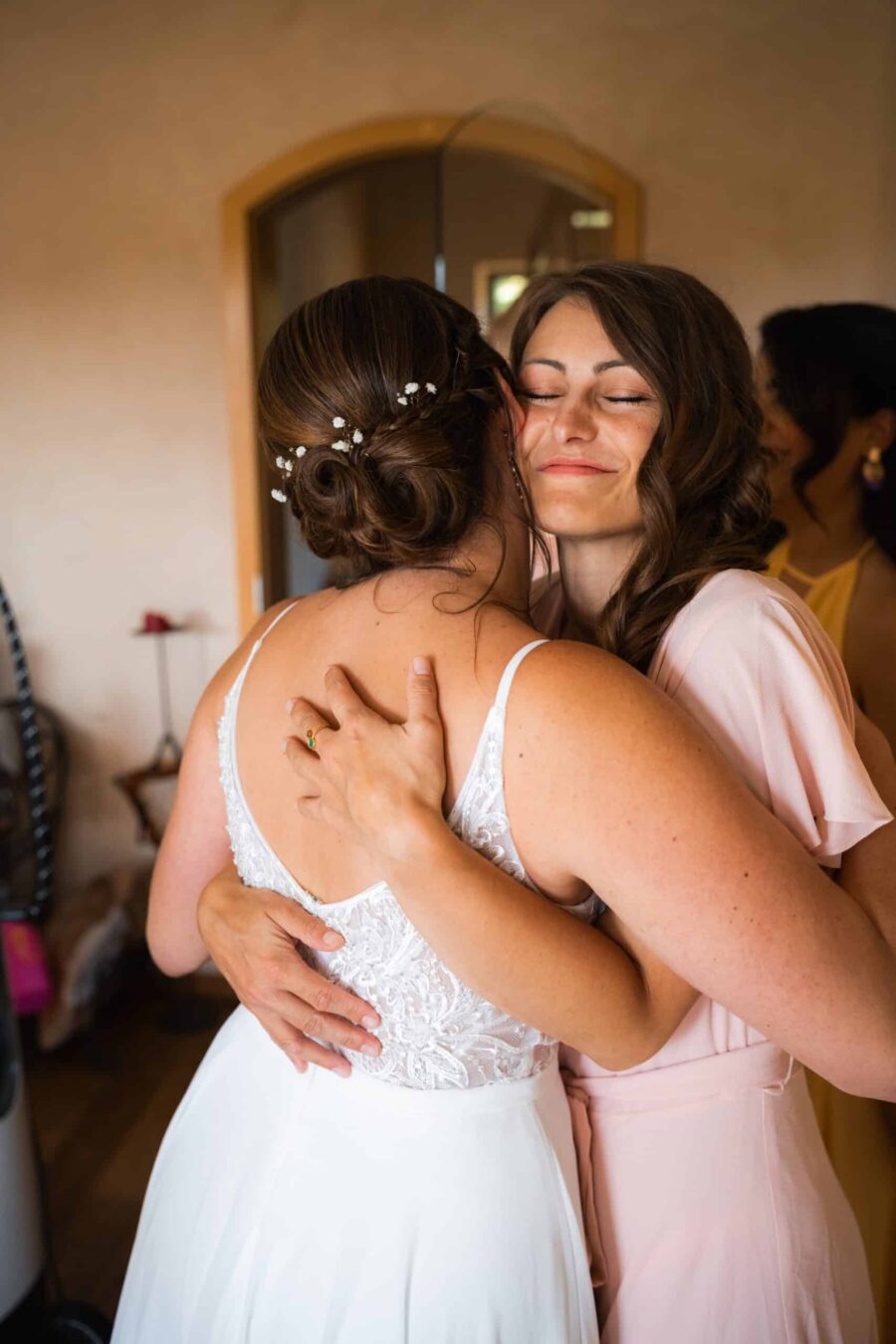 Umarmung zwischen Brautjungfern im Hochzeitszimmer