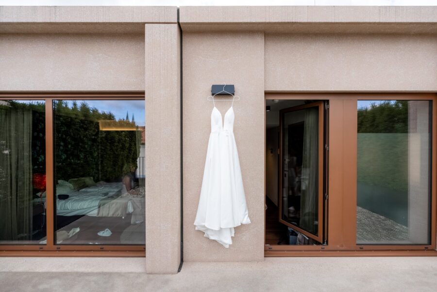 Hochzeit Villa Oriental | Editorial Summer Vibes & Live Cooking 23 Brautkleid hängt draußen an Gebäudewand