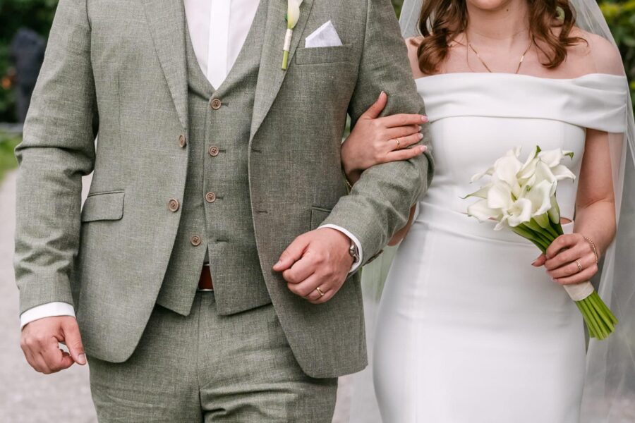 Hochzeit Insel Mainau Bodensee – Heiraten am Bodensee 141 Braut mit Begleitung Arm in Arm, Calla-Brautstrauß