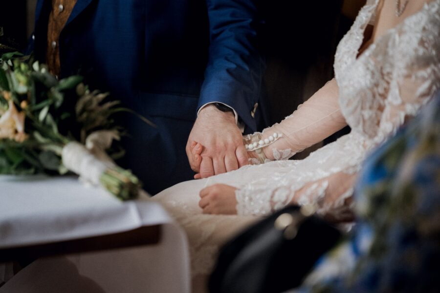 Brautpaar hält sich romantisch an den Händen.