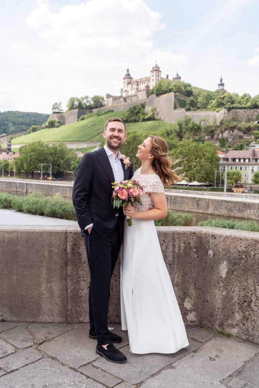 Brautpaar vor historischer Burg im Sommergarten